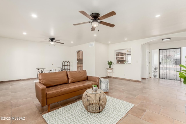 5050 N Crestridge Dr, Tucson, AZ 85718 - living room with arched walkways, recessed lighting, ceiling fan, and baseboards