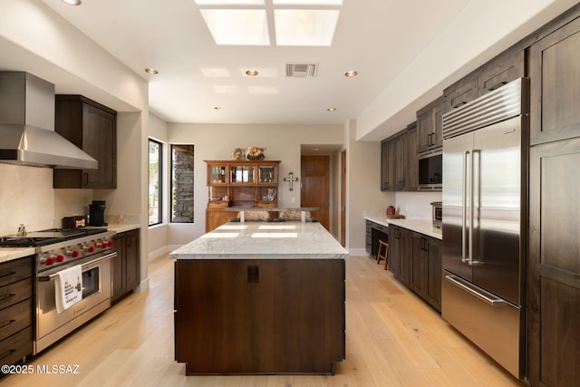 14198 N Gallery Pl, Marana, AZ 85658 - kitchen featuring built in appliances, wall chimney range hood, a kitchen island, recessed lighting, and dark brown cabinets