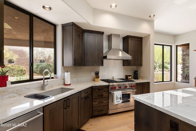 14198 N Gallery Pl, Marana, AZ 85658 - kitchen with wall chimney exhaust hood, appliances with stainless steel finishes, a sink, dark brown cabinets, and light stone countertops