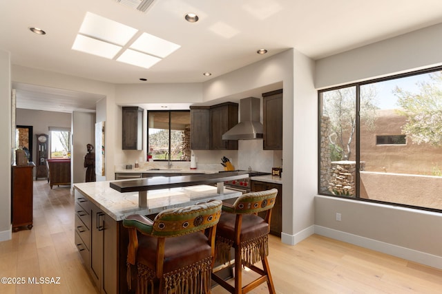 14198 N Gallery Pl, Marana, AZ 85658 - kitchen with wall chimney exhaust hood, a sink, dark brown cabinets, light wood finished floors, and recessed lighting