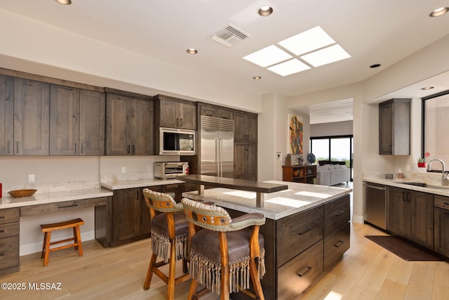 14198 N Gallery Pl, Marana, AZ 85658 - kitchen with built in appliances, a center island, a sink, dark brown cabinetry, and recessed lighting