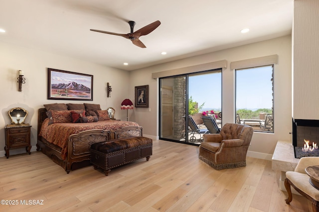 14198 N Gallery Pl, Marana, AZ 85658 - bedroom featuring access to outside, light wood-style flooring, recessed lighting, a multi sided fireplace, and baseboards