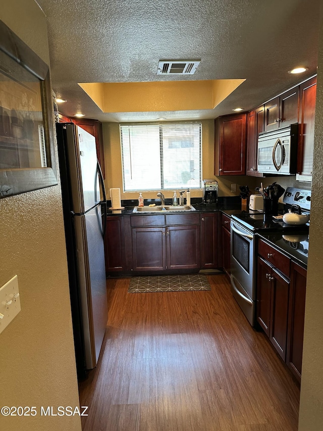 7255 E Snyder Rd # 7203, Tucson, AZ 85750 - kitchen with stainless steel appliances, a sink, dark countertops, dark wood-style flooring, and a textured ceiling