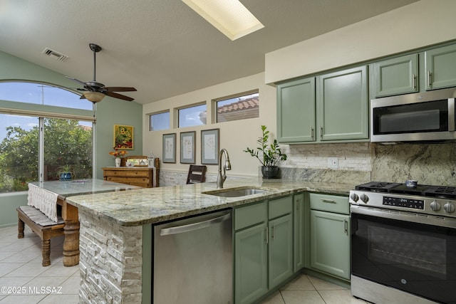 2246 E Amaranth St, Oro Valley, AZ 85755 - kitchen featuring green cabinetry, stainless steel appliances, light tile patterned flooring, a sink, and a peninsula