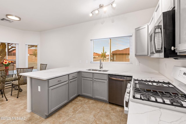 7746 S Trumpet Vine Ave, Tucson, AZ 85747 - kitchen featuring gray cabinetry, stainless steel appliances, a peninsula, a sink, and light stone counters