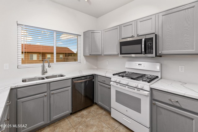 7746 S Trumpet Vine Ave, Tucson, AZ 85747 - kitchen with stainless steel appliances, gray cabinets, a sink, light tile patterned floors, and light stone counters