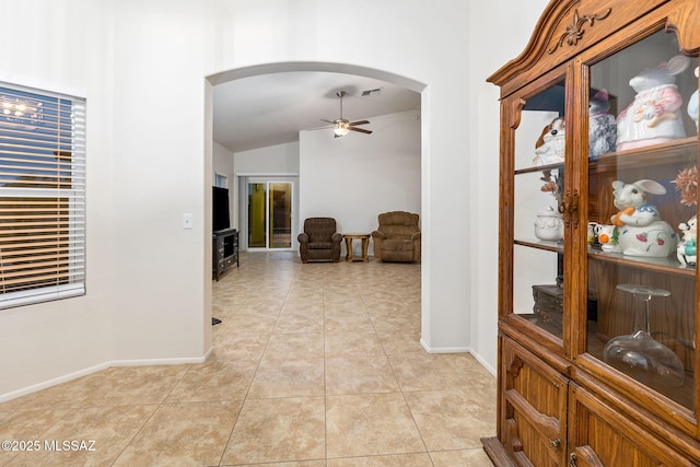 7746 S Trumpet Vine Ave, Tucson, AZ 85747 - hallway with arched walkways, vaulted ceiling, baseboards, and light tile patterned floors