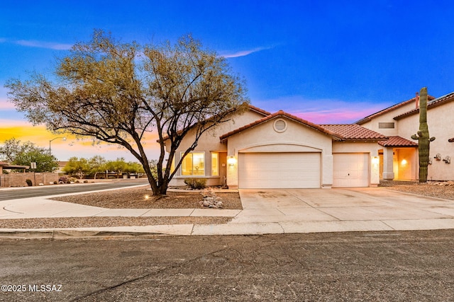 7746 S Trumpet Vine Ave, Tucson, AZ 85747 - view of front of house featuring a garage, stucco siding, driveway, and a tiled roof