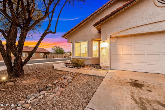 7746 S Trumpet Vine Ave, Tucson, AZ 85747 - view of home's exterior with stucco siding, concrete driveway, and a garage