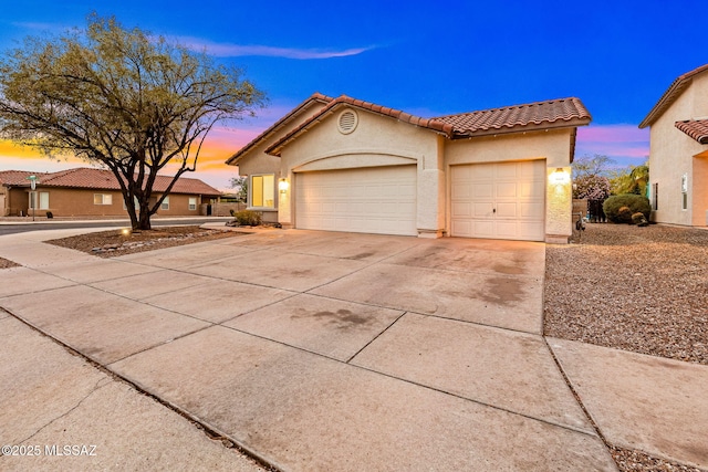 7746 S Trumpet Vine Ave, Tucson, AZ 85747 - view of front of home with concrete driveway, a tile roof, stucco siding, and an attached garage