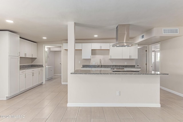 7932 E Winnepeg Dr, Tucson, AZ 85730 - kitchen featuring island exhaust hood, white cabinets, baseboards, and recessed lighting