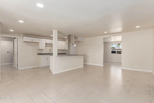 7932 E Winnepeg Dr, Tucson, AZ 85730 - kitchen with open floor plan, recessed lighting, dark countertops, white cabinetry, and baseboards