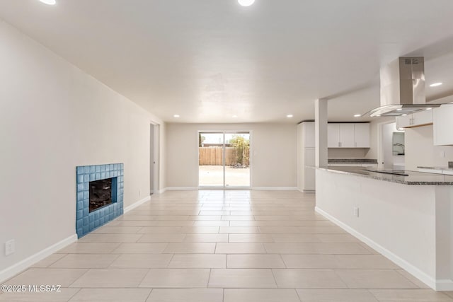 7932 E Winnepeg Dr, Tucson, AZ 85730 - unfurnished living room with recessed lighting, a tiled fireplace, and baseboards