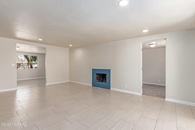 7932 E Winnepeg Dr, Tucson, AZ 85730 - unfurnished living room featuring recessed lighting, a fireplace, baseboards, and wood finish floors