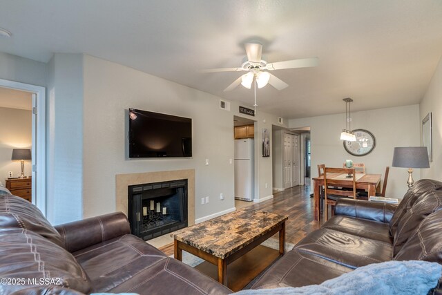 5855 N Kolb Rd Unit 1102, Tucson, AZ 85750 - living room with a ceiling fan, wood finished floors, a tile fireplace, a chandelier, and baseboards