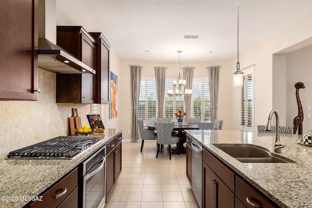 6719 W Kaibab Trl, Marana, AZ 85658 - kitchen with stainless steel appliances, a sink, wall chimney exhaust hood, tasteful backsplash, and decorative light fixtures
