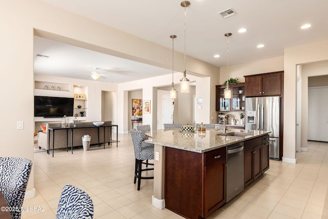 6719 W Kaibab Trl, Marana, AZ 85658 - kitchen with a sink, stainless steel appliances, open floor plan, a breakfast bar area, and light stone counters