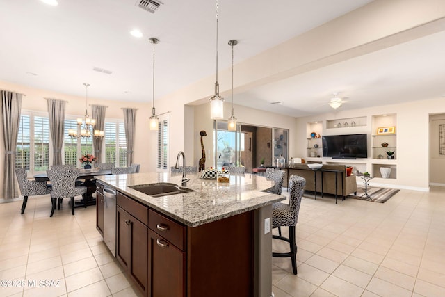 6719 W Kaibab Trl, Marana, AZ 85658 - kitchen with a sink, dishwasher, dark brown cabinets, a breakfast bar, and light tile patterned flooring