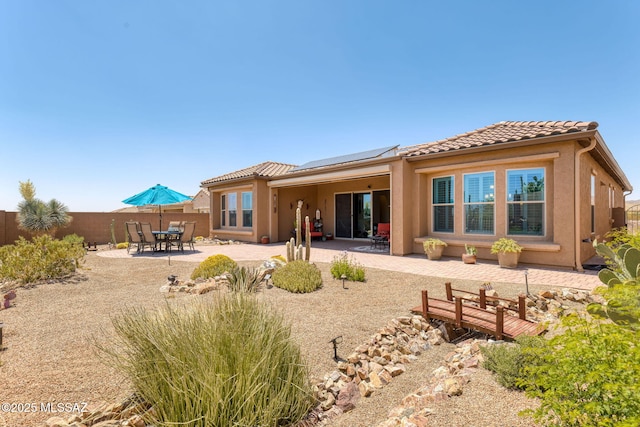 6719 W Kaibab Trl, Marana, AZ 85658 - rear view of house with roof mounted solar panels, a tile roof, a fenced backyard, and a patio area