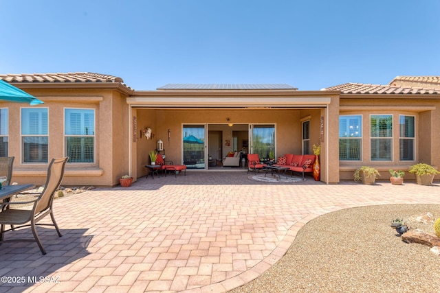 6719 W Kaibab Trl, Marana, AZ 85658 - rear view of house featuring outdoor lounge area, a patio area, solar panels, stucco siding, and a tiled roof