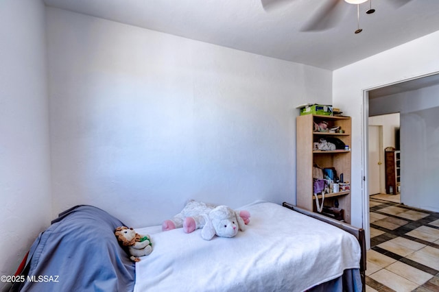 bedroom featuring inlaid floor details, light tile patterned floors, and a ceiling fan