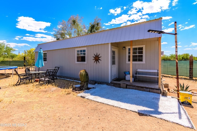 view of outbuilding with a trampoline and fence