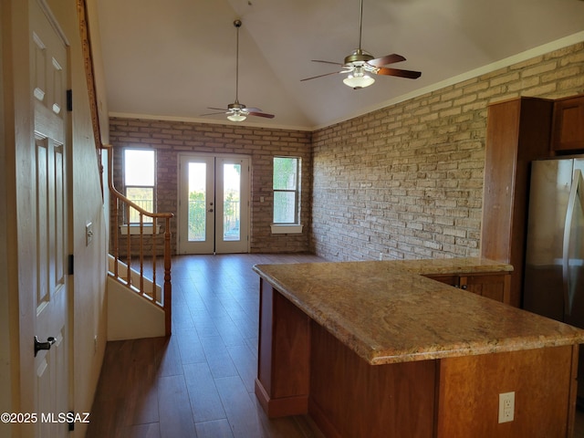 3025 N Gaia Pl, Tucson, AZ 85745 - kitchen with freestanding refrigerator, brick wall, wood-type flooring, a ceiling fan, and brown cabinets
