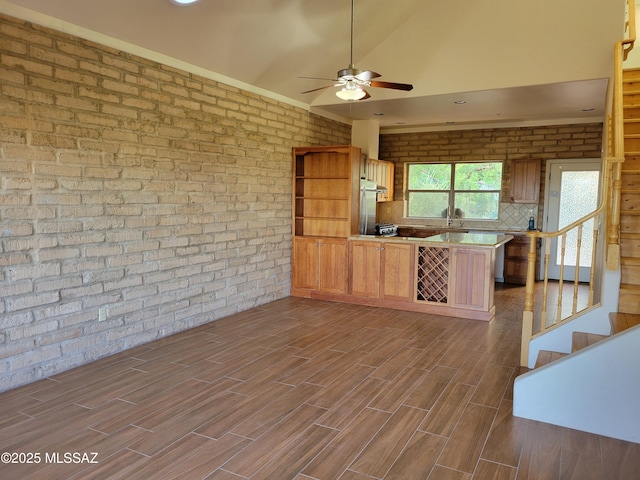 3025 N Gaia Pl, Tucson, AZ 85745 - kitchen featuring a peninsula, ceiling fan, brick wall, a sink, and dark wood-style floors