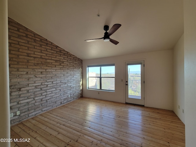 3025 N Gaia Pl, Tucson, AZ 85745 - empty room with brick wall, ceiling fan, hardwood / wood-style floors, and lofted ceiling