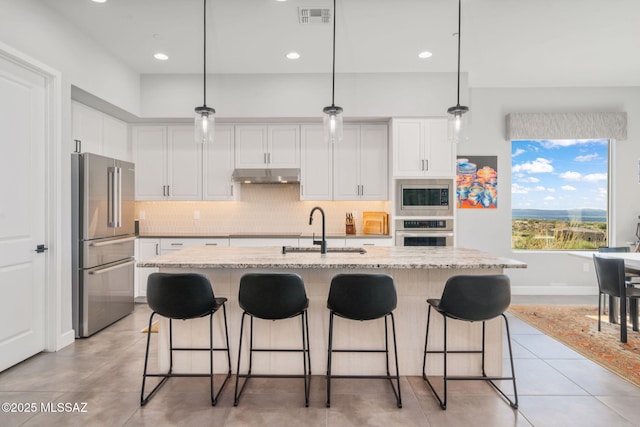 10465 E Ocotillo Rim Trl, Vail, AZ 85641 - kitchen with stainless steel appliances, a sink, under cabinet range hood, backsplash, and white cabinets