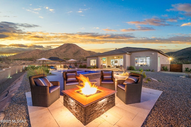 10465 E Ocotillo Rim Trl, Vail, AZ 85641 - patio terrace at dusk featuring a mountain view and an outdoor living space with a fire pit