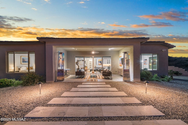 10465 E Ocotillo Rim Trl, Vail, AZ 85641 - back of house at dusk featuring a patio and stucco siding