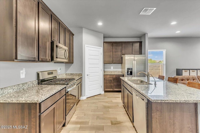 10094 N Cardon Grande Trl, Marana, AZ 85653 - kitchen featuring appliances with stainless steel finishes, a sink, recessed lighting, light wood finished floors, and dark brown cabinetry