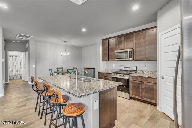 10094 N Cardon Grande Trl, Marana, AZ 85653 - kitchen featuring stainless steel appliances, a sink, light wood-style floors, light stone countertops, and recessed lighting