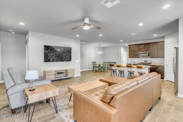 10094 N Cardon Grande Trl, Marana, AZ 85653 - living room with ceiling fan, recessed lighting, light wood-type flooring, a chandelier, and baseboards