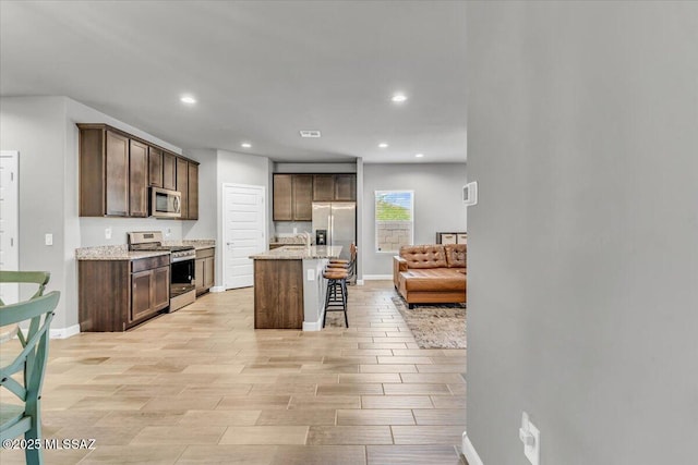 10094 N Cardon Grande Trl, Marana, AZ 85653 - kitchen featuring appliances with stainless steel finishes, dark brown cabinetry, a breakfast bar, recessed lighting, and a sink