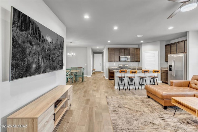 10094 N Cardon Grande Trl, Marana, AZ 85653 - living area featuring light wood-type flooring, recessed lighting, a ceiling fan, a chandelier, and baseboards