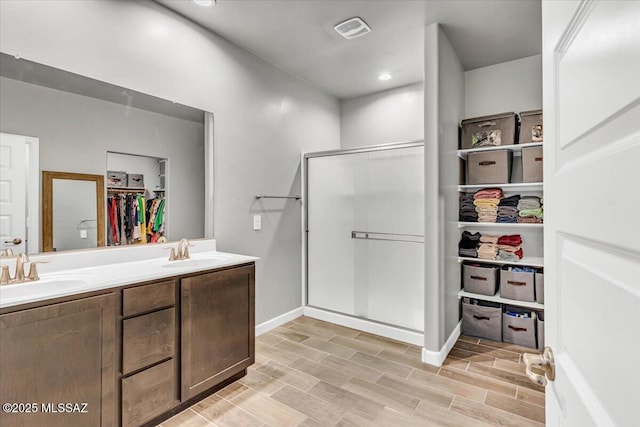 10094 N Cardon Grande Trl, Marana, AZ 85653 - full bathroom with a walk in closet, a stall shower, double vanity, and wood finished floors