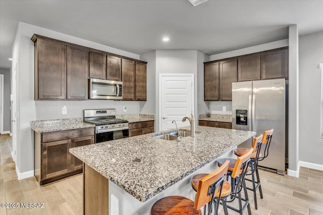10094 N Cardon Grande Trl, Marana, AZ 85653 - kitchen with stainless steel appliances, a sink, baseboards, light wood-style flooring, and recessed lighting