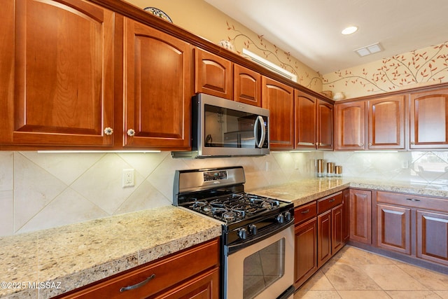 2337 S Via Vespucci, Green Valley, AZ 85614 - kitchen featuring appliances with stainless steel finishes, decorative backsplash, recessed lighting, light tile patterned floors, and light stone counters