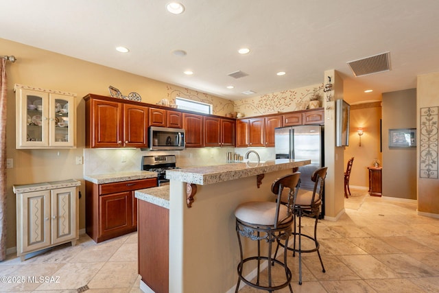 2337 S Via Vespucci, Green Valley, AZ 85614 - kitchen with appliances with stainless steel finishes, light countertops, a breakfast bar, a kitchen island with sink, and recessed lighting