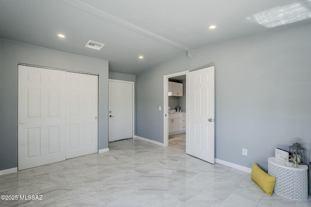 unfurnished bedroom featuring light marble finish floors, baseboards, recessed lighting, a closet, and lofted ceiling