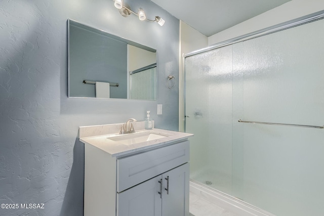 full bathroom featuring a shower stall, vanity, and marble finish flooring