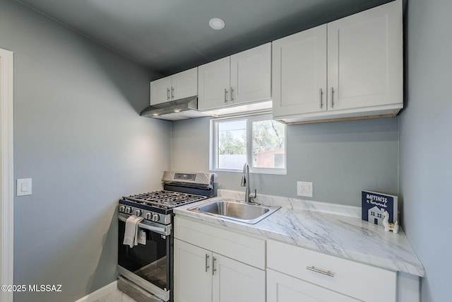 kitchen with stainless steel range with gas cooktop, under cabinet range hood, a sink, and white cabinetry