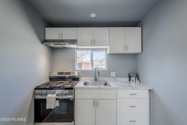 kitchen with stainless steel gas range oven, a sink, under cabinet range hood, and white cabinetry