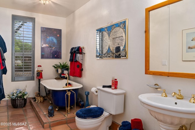 bathroom featuring a sink, a soaking tub, toilet, and tile patterned floors