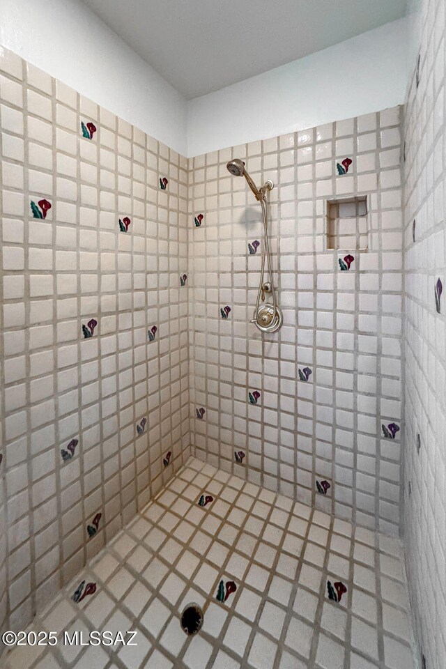 bathroom featuring tiled shower and tile patterned floors