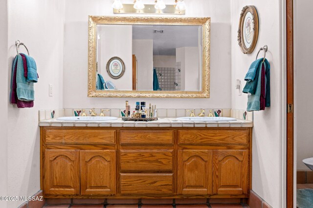 bathroom with double vanity and baseboards