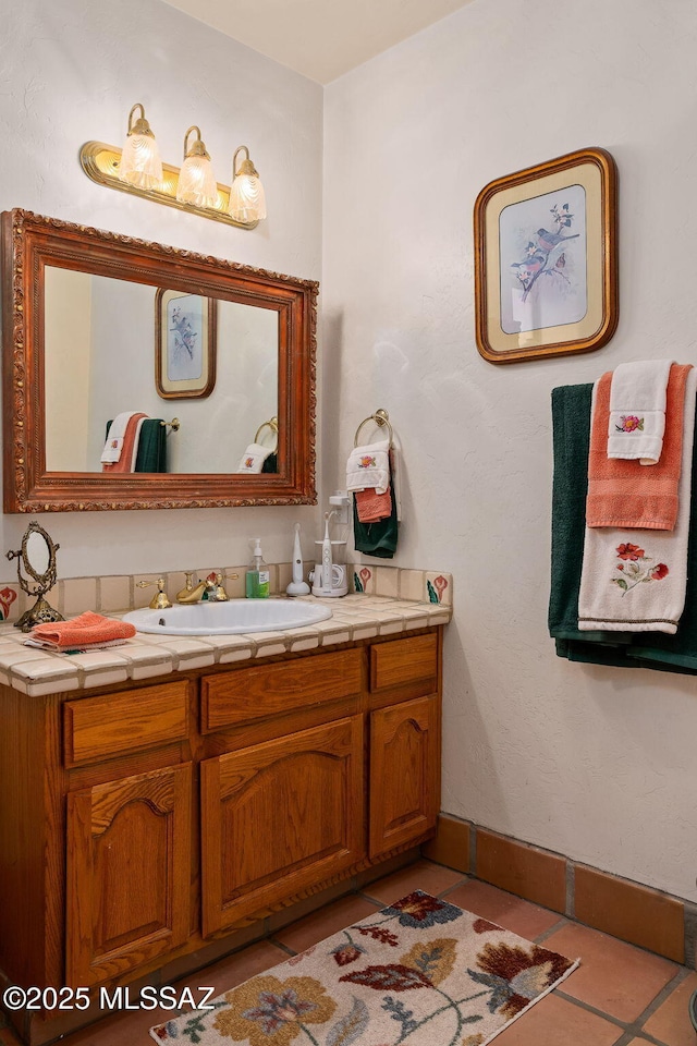 bathroom featuring vanity, tile patterned flooring, and baseboards