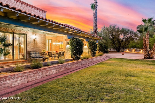 yard at dusk featuring a yard